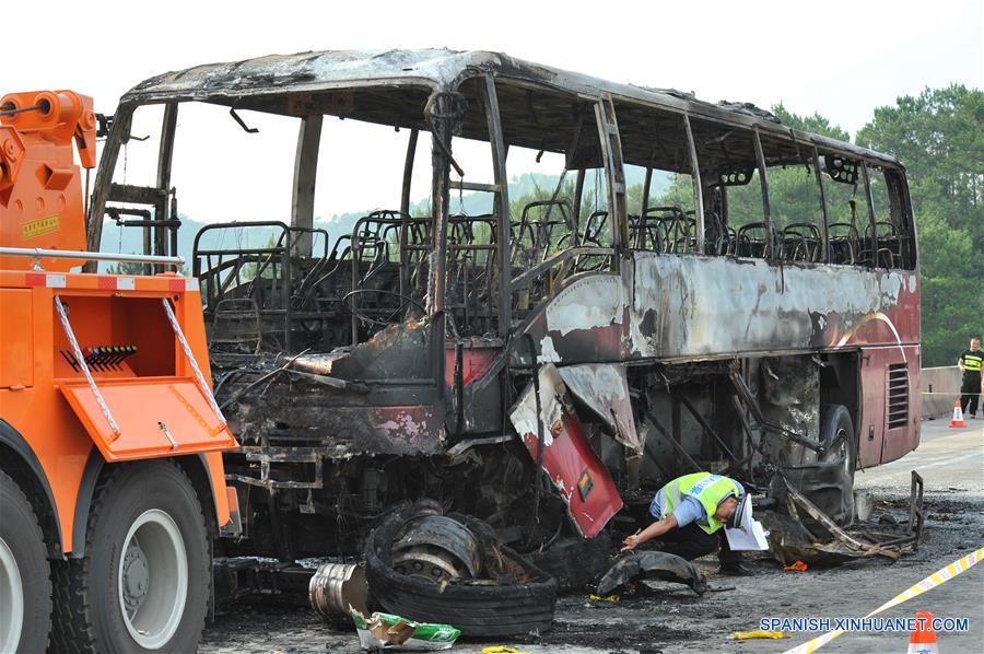 Un policía de tránsito examina un sitio del accidente en el condado de Yizhang, en la provincia central de Hunan, en China, el 26 de junio de 2016. Un incendio que redujo a un autobús turístico a una estructura carbonizada el domingo por la ma?ana ha provocado la muerte de al menos 35 personas, incluidos dos ni?os, en la provincia central china de Hunan, confirmaron las autoridades locales. El accidente se produjo hacia las 10:20 horas, cuando el autobús chocó contra las barreras de protección en una autopista de Yizhang. (Xinhua/Long Hongtao)
