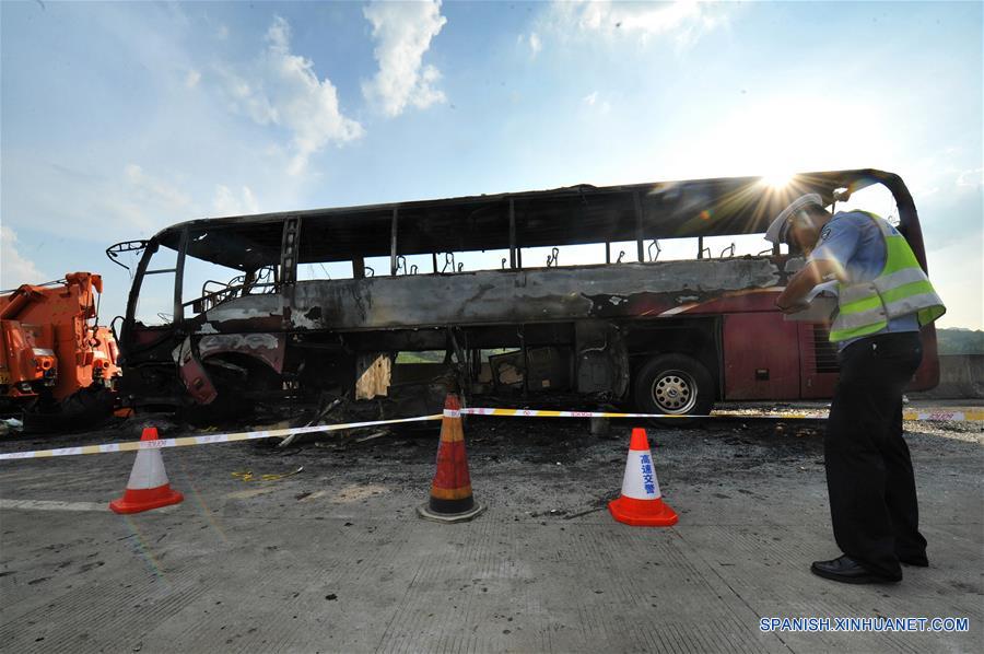 Un policía de tránsito examina un sitio del accidente en el condado de Yizhang, en la provincia central de Hunan, en China, el 26 de junio de 2016. Un incendio que redujo a un autobús turístico a una estructura carbonizada el domingo por la ma?ana ha provocado la muerte de al menos 35 personas, incluidos dos ni?os, en la provincia central china de Hunan, confirmaron las autoridades locales. El accidente se produjo hacia las 10:20 horas, cuando el autobús chocó contra las barreras de protección en una autopista de Yizhang. (Xinhua/Long Hongtao)
