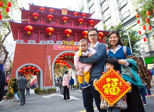 Una familia desea "feliz a?o nuevo" para todo el mundo mientras disfruta del mercado de las flores de Guangzhou. [Foto: proporcionada]