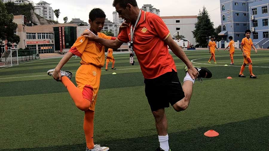 El entrenador espa?ol José (derecha) y el chileno Piri estrenan a ni?os chinos en la escuela Zhenghua en la ciudad de Kaili, suroeste de China.