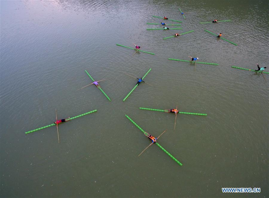 Estudiantes practican sobre una rama de bambú en los canales de Guizhou
