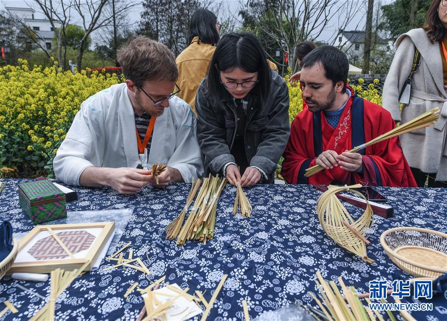 El 31 de marzo, un visitante de Bélgica (izquierda) y otro de Espa?a, vestidos con trajes Hanfu, experimentaron la artesanía tradicional local del bambú en Taoyuan.