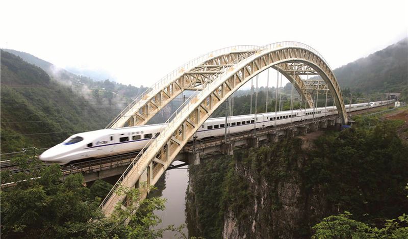Un tren bala pasa por un puente en Enshi, provincia de Hubei, en el centro de China, el 1 de julio de 2014. Enshi es la primera prefectura autónoma en China que tuvo acceso al ferrocarril de alta velocidad, lo que ayudó a sacar a la región de la pobreza. [Foto de Teng Jun / para China Daily]