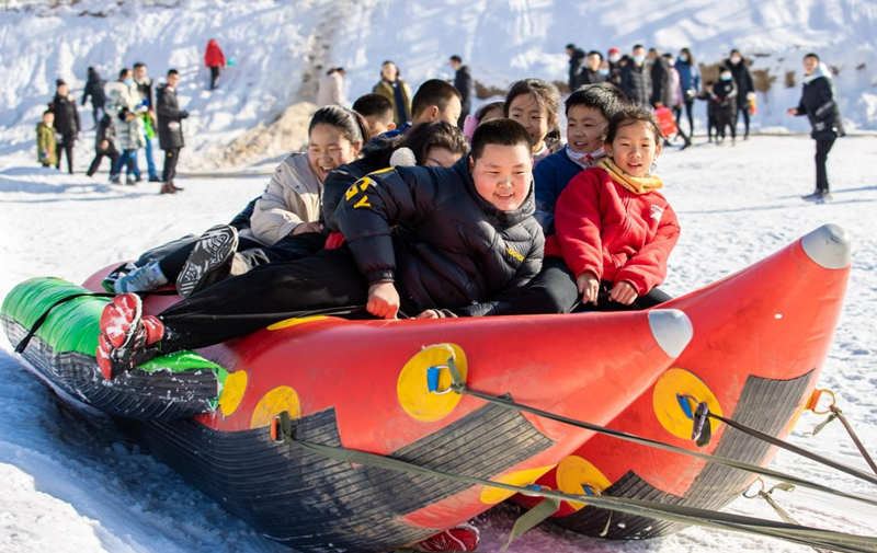 El 19 de diciembre de 2021, los ni?os se divierten en unos plátanos inflables en la nieve en el Parque de Hielo y Nieve de la Aldea Dakulun, en Hohhot, región autónoma de Mongolia Interior. Ding Genhou / Pueblo en Línea