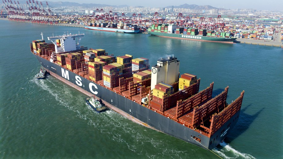 Vista aérea del 27 de enero de 2023 de un buque portacontenedores atracando en la Terminal de Contenedores de Qianwan del Puerto de Qingdao con la ayuda de remolcadores, en la provincia de Shandong, en el este de China. (Xinhua/Li Ziheng)