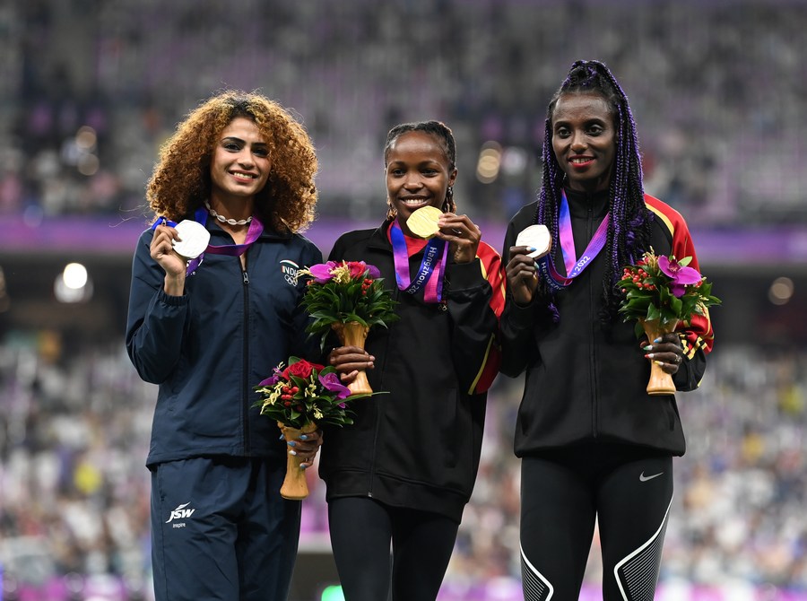 La medallista de oro Winfred Mutile Yavi (centro) de Bahréin, la medallista de plata Harmilan Bains (izq.) de India y la medallista de bronce Marta Hirpato Yota de Bahréin, asisten a la ceremonia de victoria de los 1.500 metros femeninos de atletismo en los XIX Juegos Asiáticos en Hangzhou, provincia de Zhejiang, en el este de China, el 1 de octubre de 2023. (Xinhua/Jiang Han)