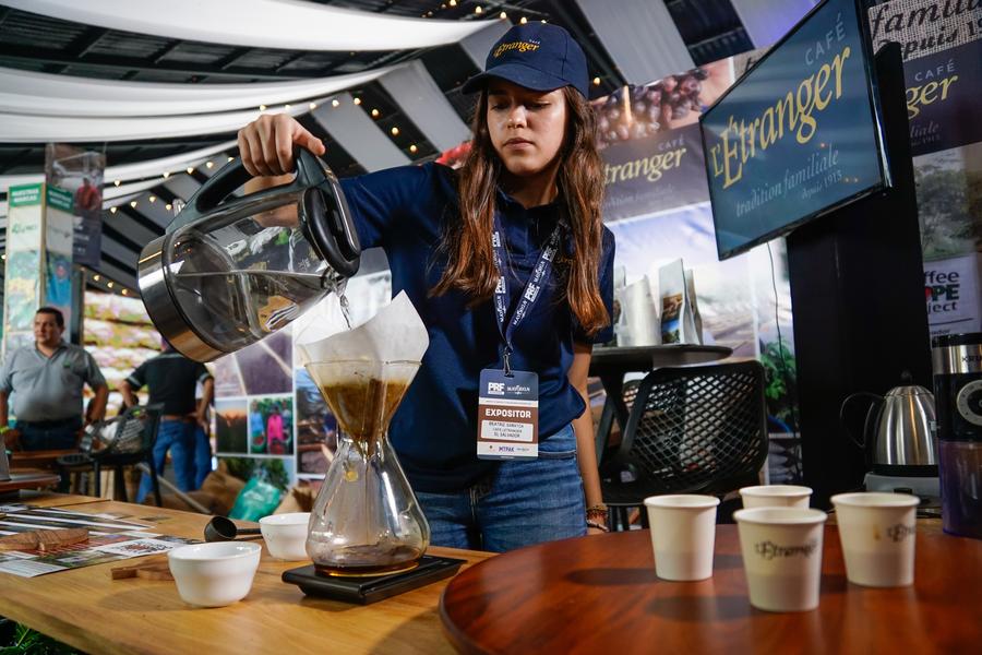 Una comerciante de café prepara una bebida durante la sexta edición del Foro de Productores y Tostadores de Café, en Nuevo Cuscatlán, en el departamento de La Libertad, El Salvador, el 16 de marzo de 2023. (Xinhua/Alexander Pe?a)