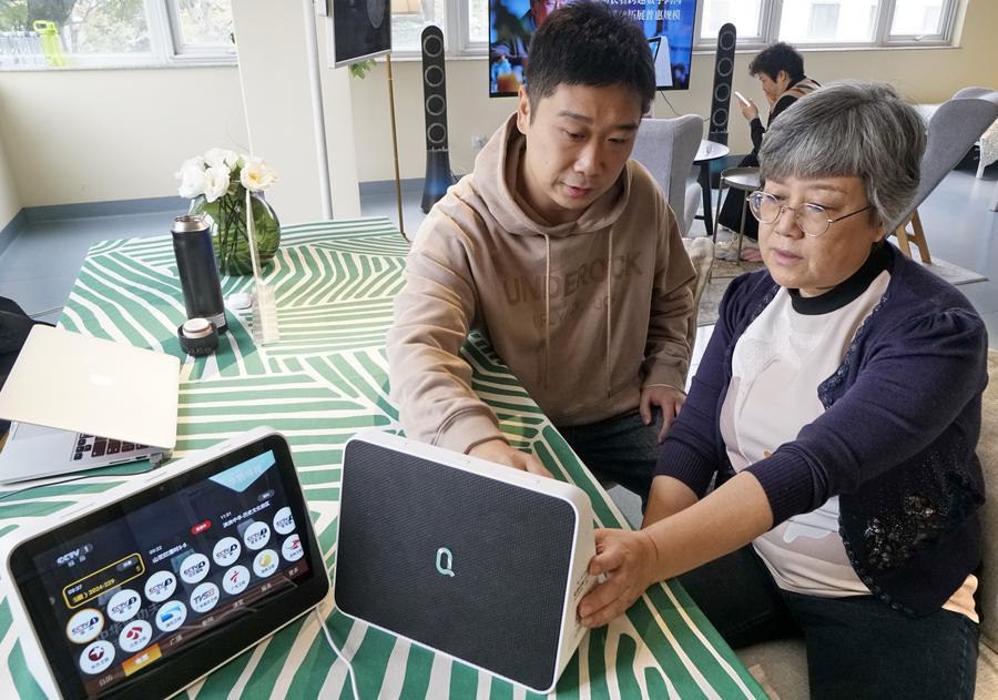 Un miembro del personal de un centro de servicios de atención a personas mayores guía a una anciana sobre el uso de dispositivos inteligentes en el distrito de Dongcheng en Beijing, capital de China, el 31 de octubre de 2024. (Xinhua/Li Xin)