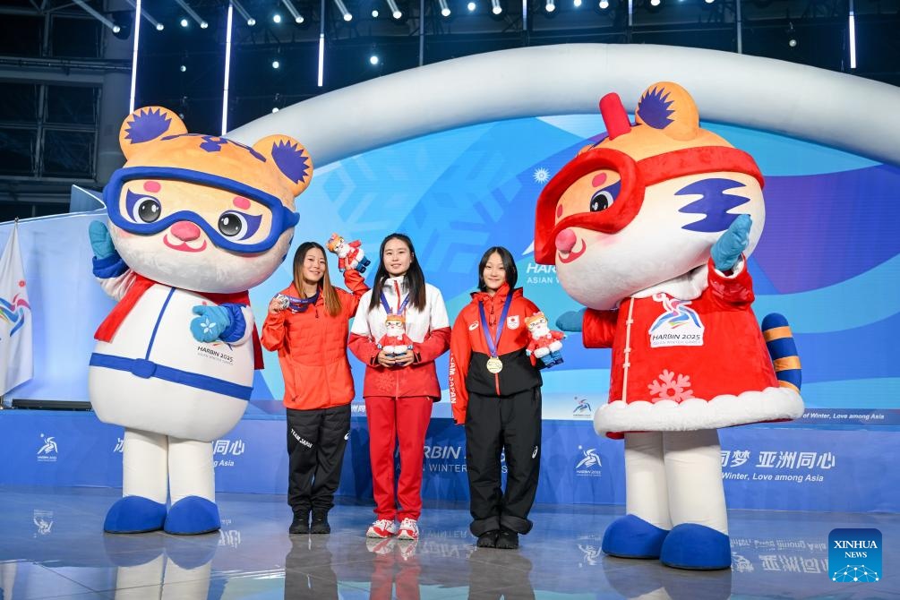La medallista de oro Shimizu Sara (d), de Japón, la medallista de plata Tomita Sena (i), de Japón, y la medallista de bronce Wu Shaotong, de China, reaccionan en la ceremonia de victoria para medio tubo de snowboard femenino en los IX Juegos Asiáticos de Invierno, en Yabuli, en la provincia de Heilongjiang, en el noreste de China, el 13 de febrero de 2025. (Xinhua/Lian Zhen)