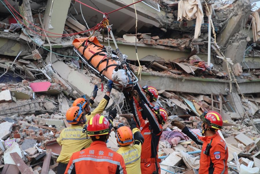 Miembros del equipo chino de Búsqueda y Rescate y del unidad civil de Ramunion Rescue trasladaron conjuntamente a un sobreviviente en un sitio sísmico en Mandalay, Myanmar, el 31 de marzo, 2025. (Xinhua/Myo Kyaw Soe)