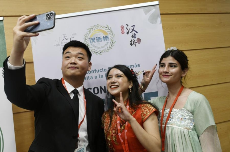Imagen del 9 de junio de 2022 de concursantes posando para una fotografía con un trabajador al término del 21 Concurso de Dominio del Idioma Chino "Puente Chino" para estudiantes universitarios chilenos en la Universidad Santo Tomás, en Vi?a del Mar, Chile. (Xinhua/Universidad Santo Tomás)