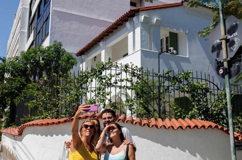 Personas se toman una fotografía frente a la casa utilizada como lugar de rodaje de la película brasile?a "Aún Estoy Aquí", en el barrio de Urca, en Río de Janeiro, Brasil, el 5 de marzo de 2025. (Xinhua/Claudia Martini)