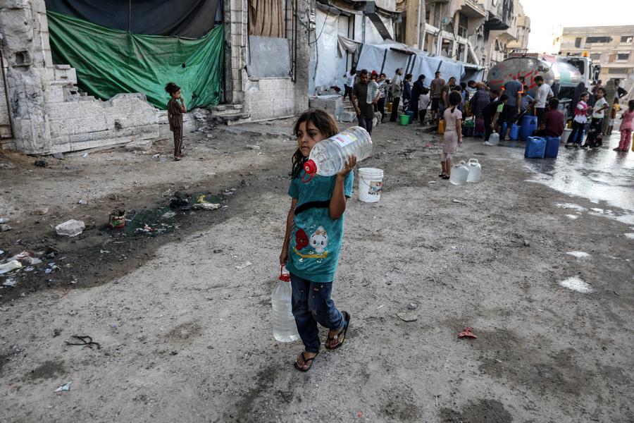 Imagen del 25 de agosto de 2025 de una ni?a palestina desplazada recolectando agua en un refugio temporal, en el noroeste de la Ciudad de Gaza. (Xinhua/Rizek Abdeljawad)